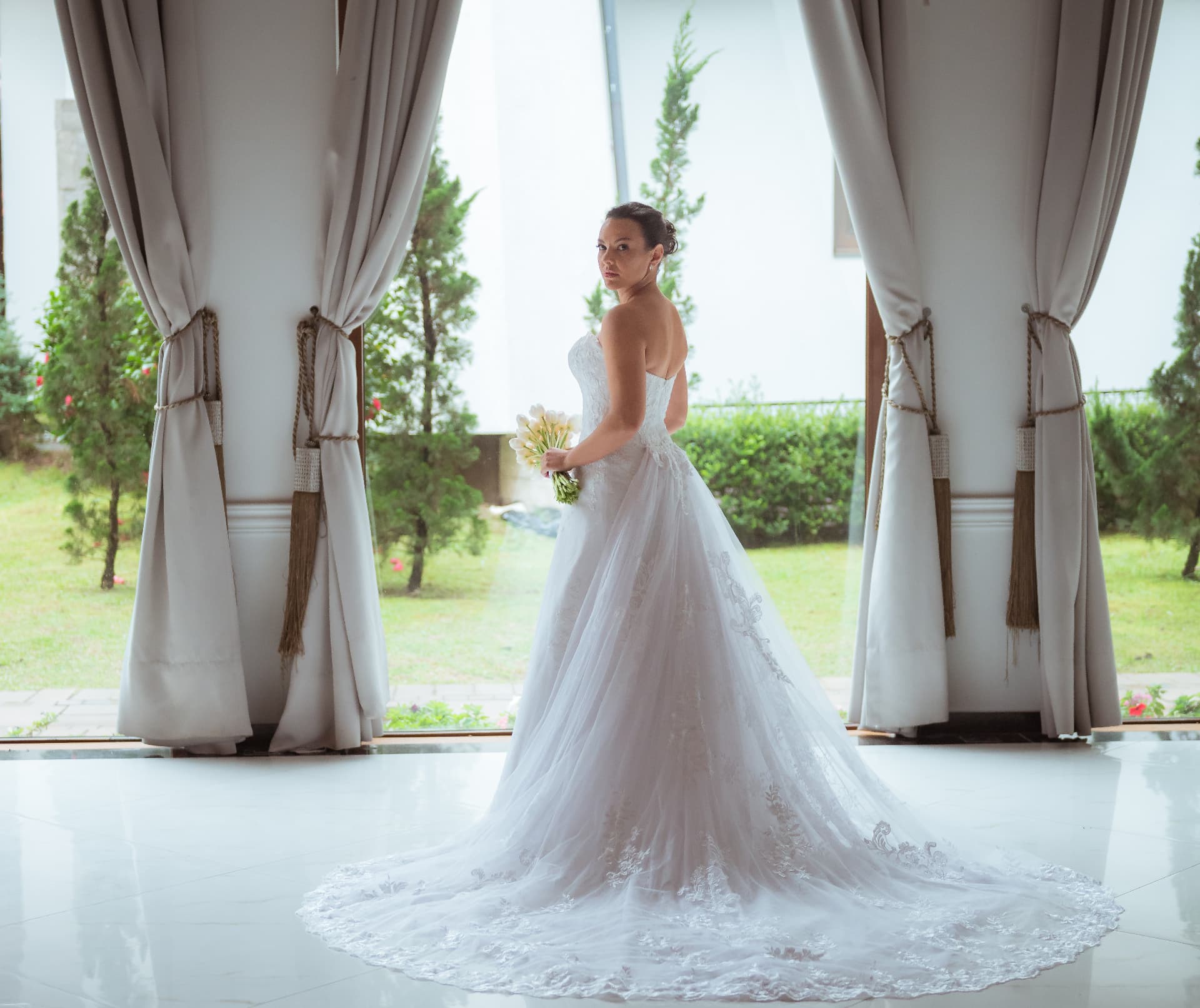 Caroline com o buquê de tulipas e a cauda do vestido