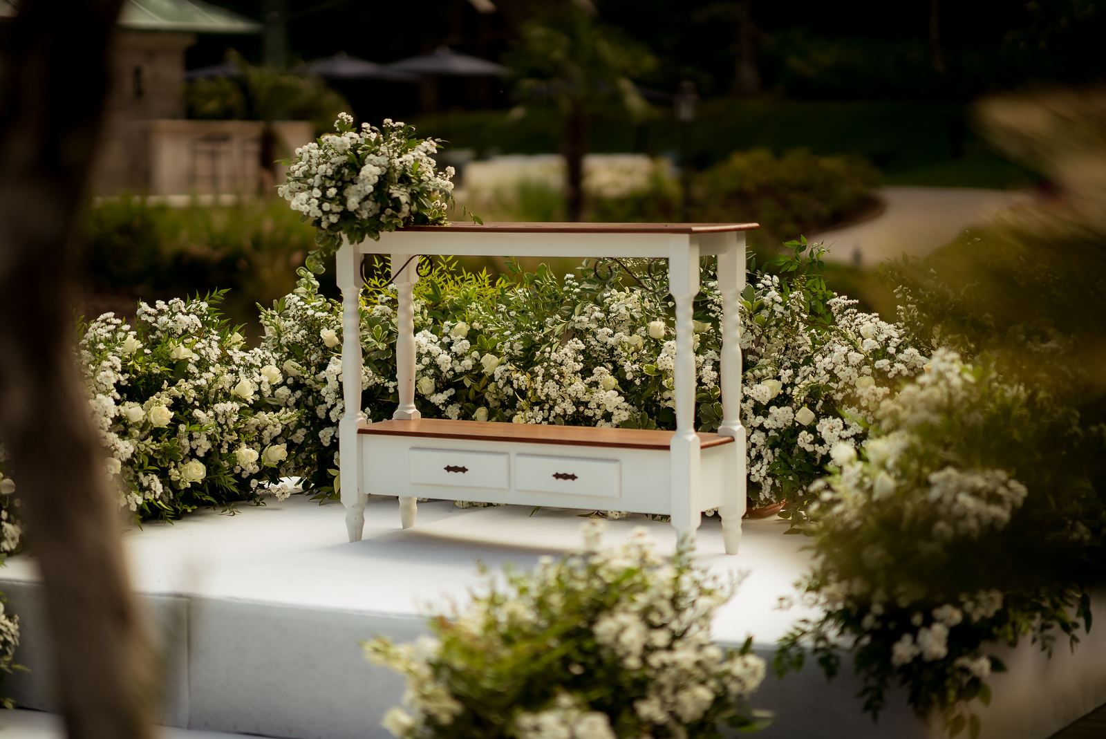 Altar com móvel branco cercado de flores brancas